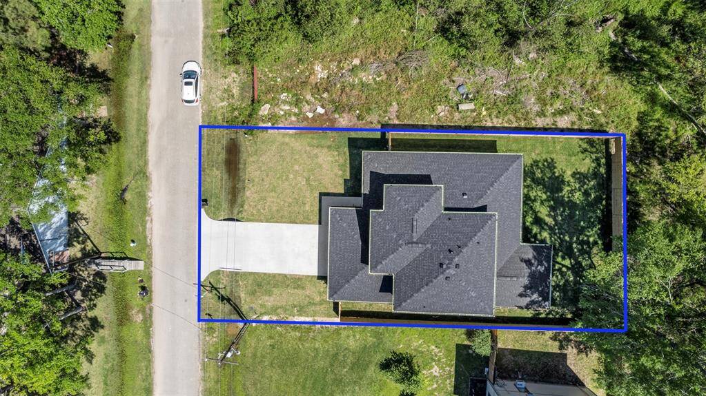 Bird’s-eye view of the property boundaries outlined, showcasing the size of the lot and its position on a quiet, tree-lined street.