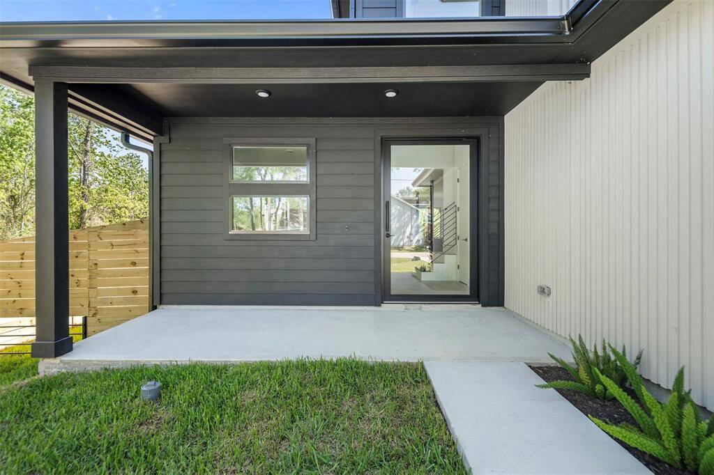 Striking modern entry featuring a custom pivot door and covered porch