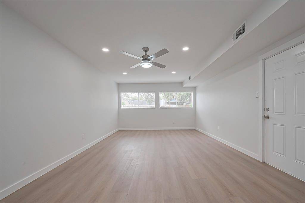 This dining room is also brightened by recessed lighting and a ceiling fan, creating a comfortable atmosphere for meals or gatherings.