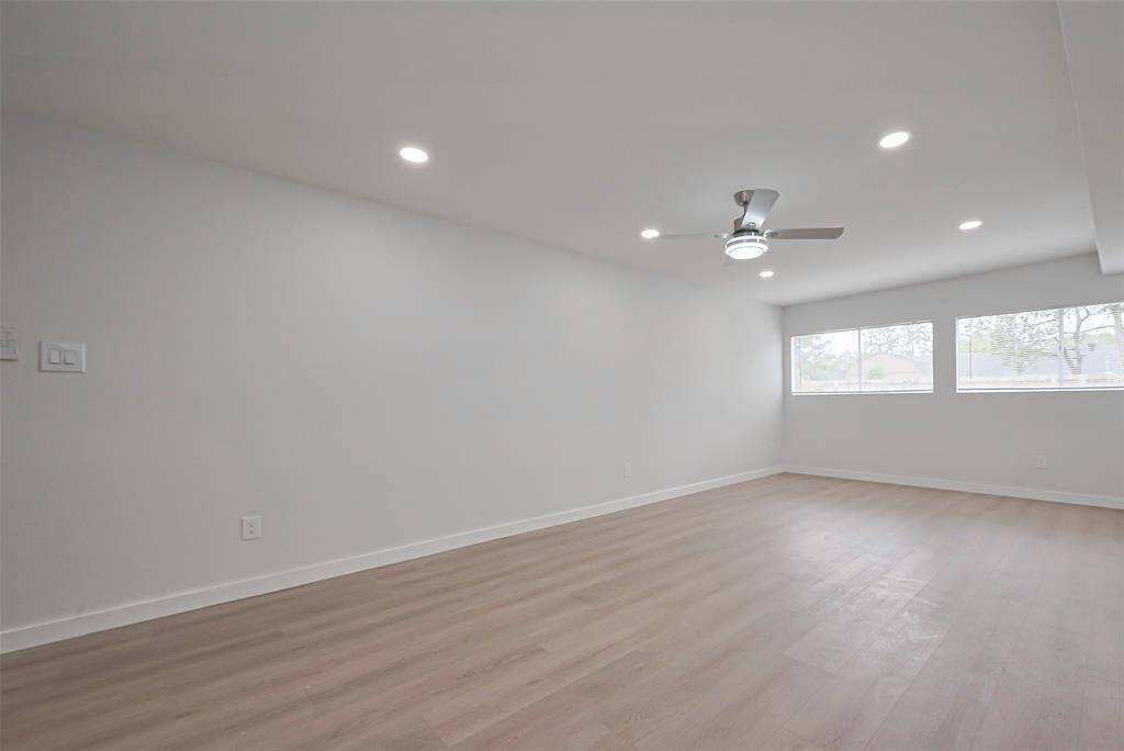 The formal dining room continues the home's theme of spaciousness, featuring the same warm laminate flooring and large windows that invite natural light.
