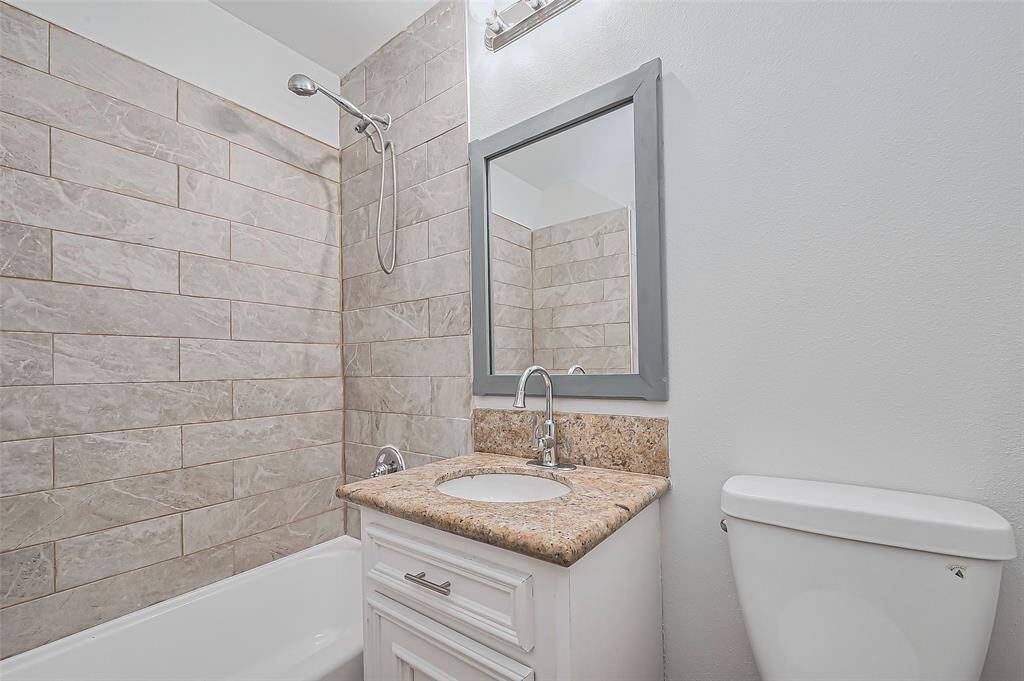 The full bathroom is tastefully tiled, featuring a well-designed vanity and a shower/tub combo, creating a functional and comfortable space.