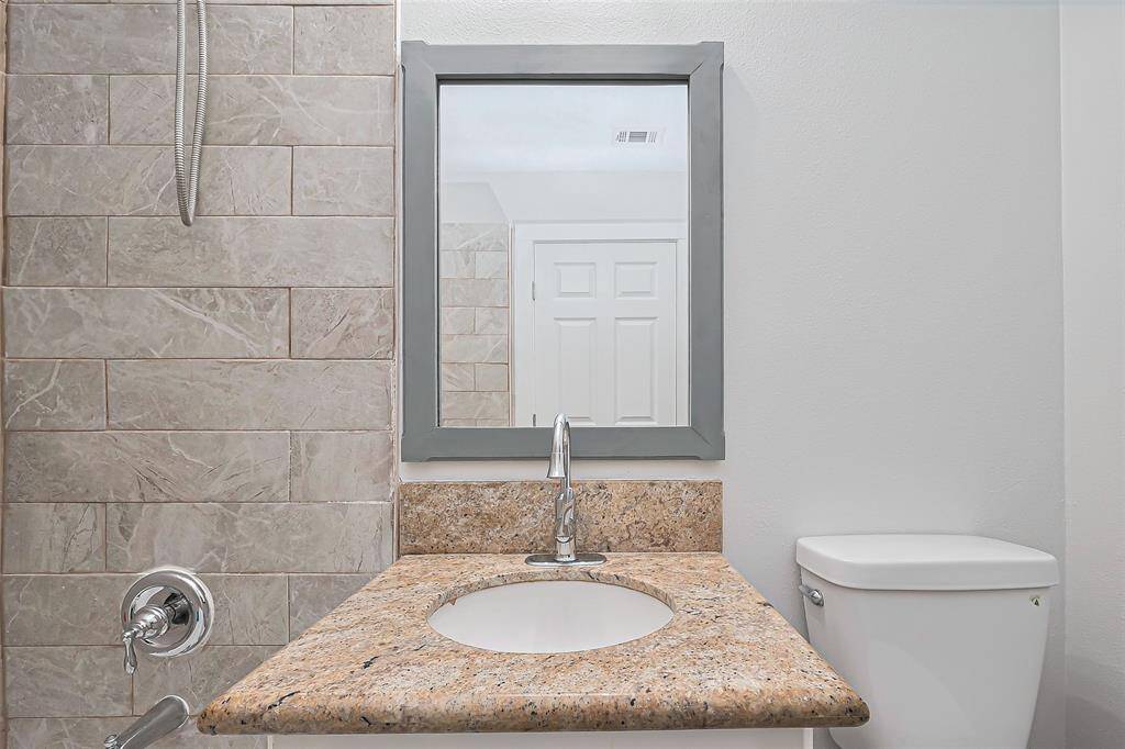 A close-up of the bathroom vanity highlights its compact yet complete setup, including a mirror, sink, and storage below for convenience.