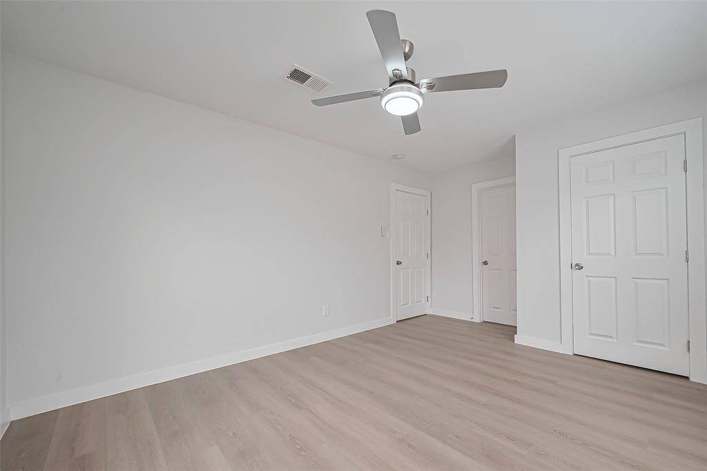 Like the other rooms, the primary bedroom is floored with warm laminate and finished with light walls, creating an open and peaceful atmosphere.
