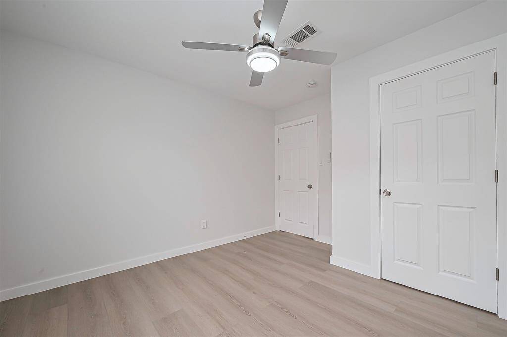 Spacious and versatile, this bedroom is complete with the same laminate flooring and neutral walls, offering an ideal setting for rest or study.