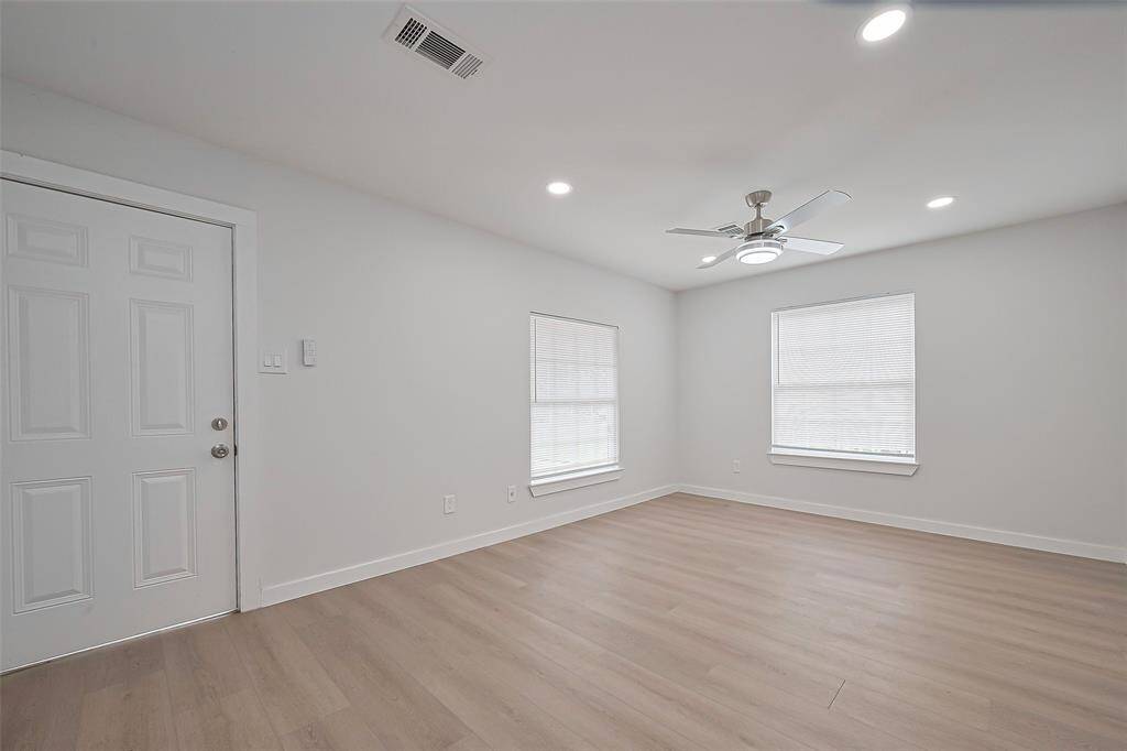 The living room is beautifully illuminated by recessed lighting along with a gentle glow from the ceiling fan, enhancing the space’s warmth and brightness.