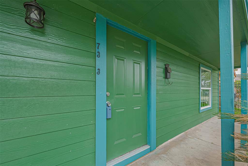 A closer look at the front door reveals the expansive front porch running the length of the home’s façade, inviting relaxation and a warm welcome.