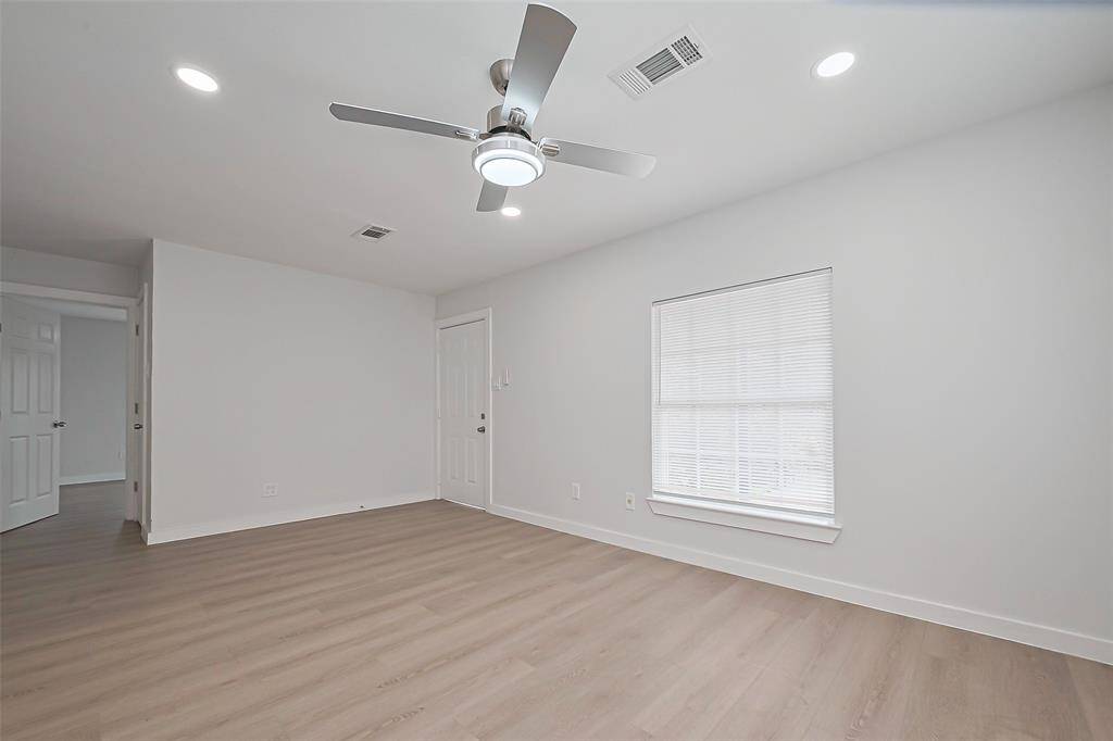 This expansive living room, with its ample square footage, is the heart of the home, with cozy areas to the right leading to the bedrooms.