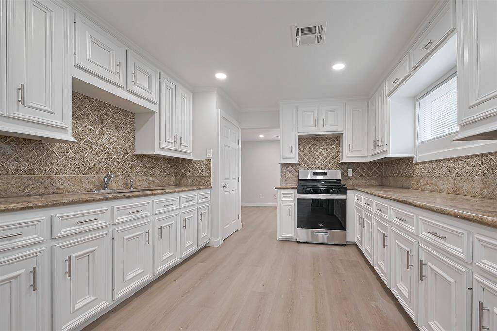 The kitchen offers an abundance of space, with an impressive amount of cabinetry and expansive countertops. A perfect setup for culinary endeavors.