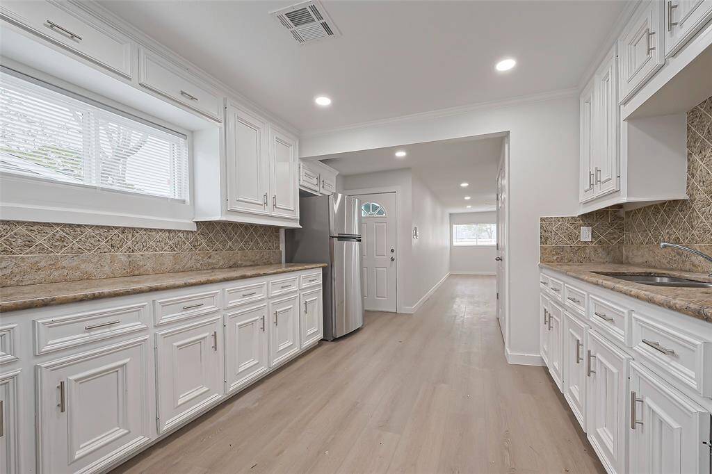 The galley-style kitchen layout is both efficient and spacious, offering an open feel with plenty of room between counters, and conveniently open to the dining area.