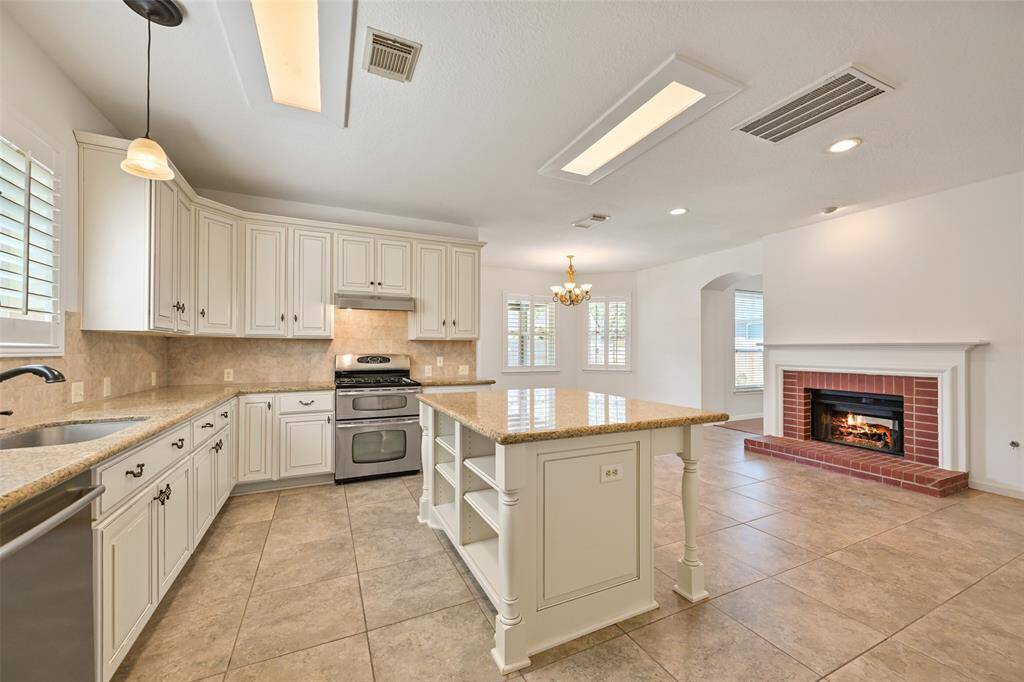 OPEN-CONCEPT KITCHEN AND KITCHENETTE WITH BUILT-IN SHELVING, AND A BRIGHT, INVITING SPACE FOR EVERYDAY GATHERINGS.