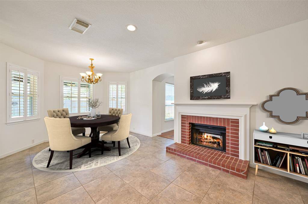 LIGHTT AND BRIGHT BREAKFAST AREA SURROUNDED BY DUAL PANE WINDOWS WITH PLANTATION SHUTTERS—PERFECT FOR ENJOYING MORNING COFFEE BY THE COZY DOUBLE-SIDED FIREPLACE. **This room has been virtually staged.