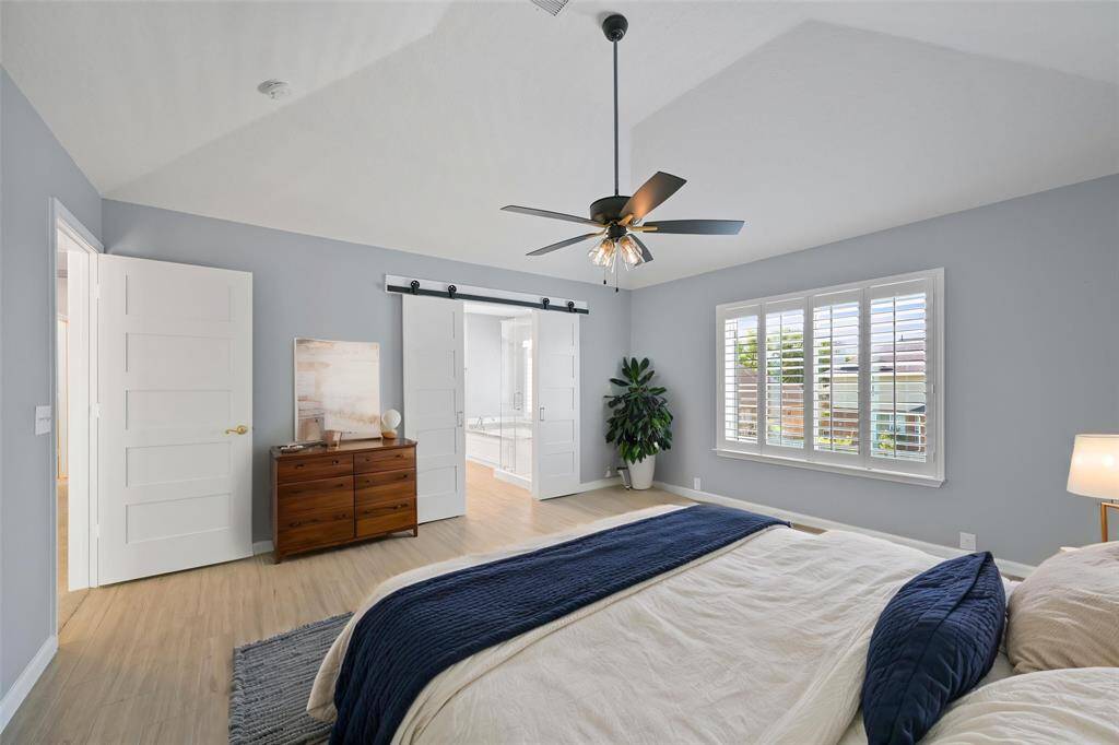 RELAX IN STYLE IN THIS PRIMARY SUITE FEATURING A BARN DOORS TO THE UPDATED ENSUITE BATHROOM. **This room has been virtually staged.