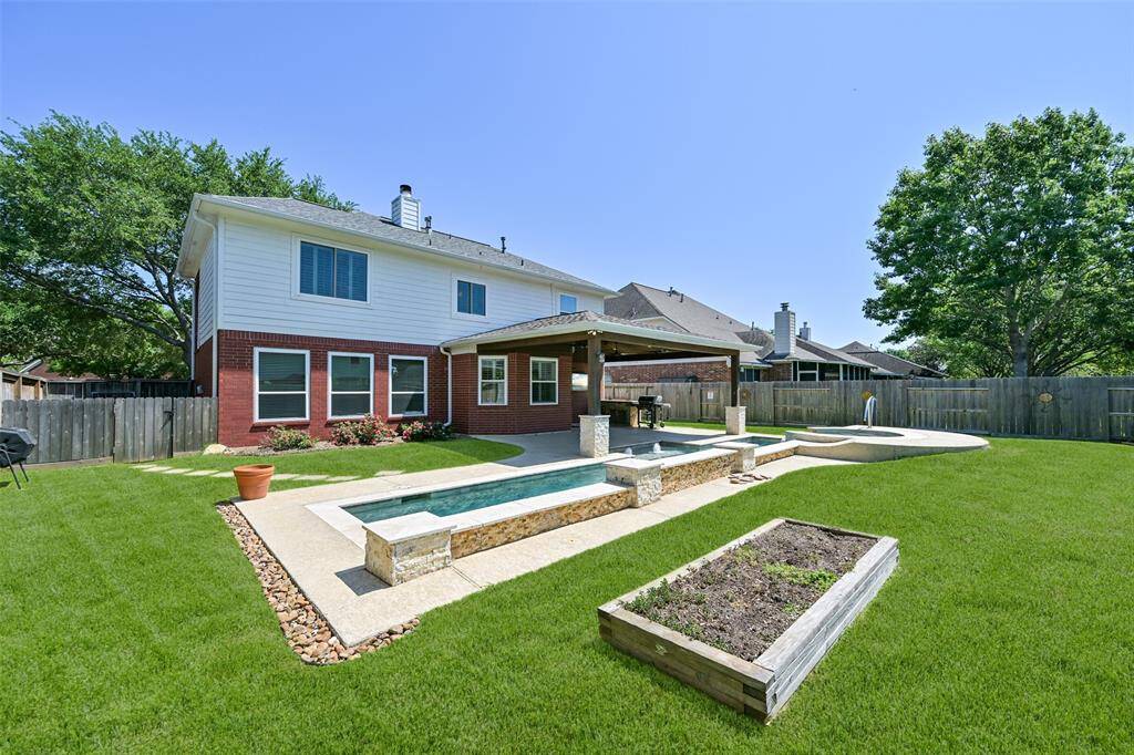 SPRAWLING BACKYARD RETREAT WITH SIDE AND BACK FENCES WITH ADDED CORRAL BOARD BASES FOR EXTRA DURABILITY AND STYLE.