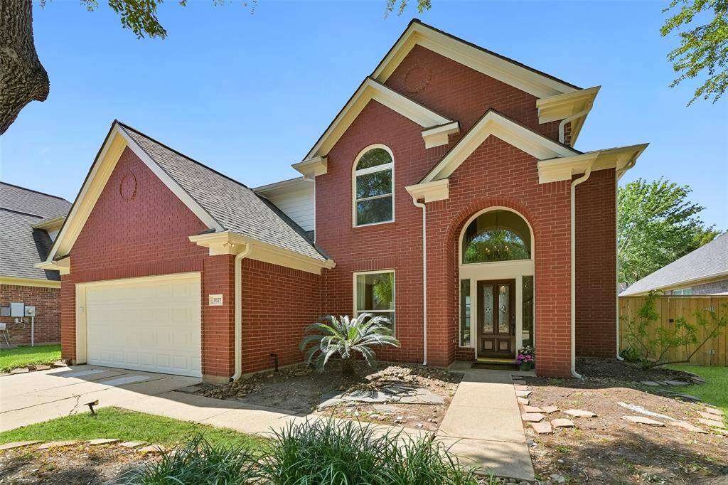 THIS 4 BEDROOM, 2.5 BATH HOME FEATURES A CLASSIC BRICK EXTERIOR, MATURE TREES, AND A SOARING ENTRYWAY.