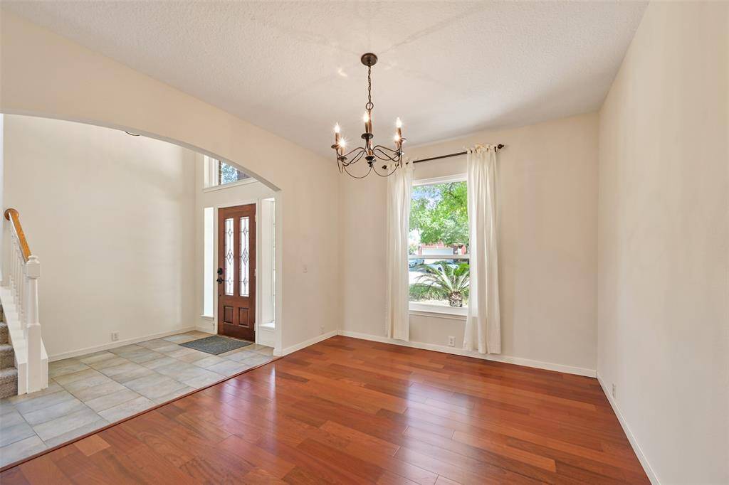 HOST IN STYLE IN THIS INVITING DINING SPACE FEATURING AN ARCHED ENTRY AND TILE-TO-WOOD TRANSITION.