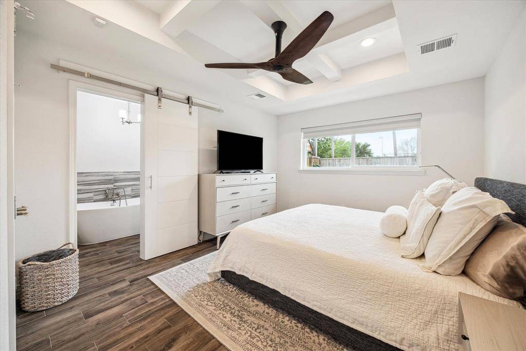 The luxurious primary bedroom is serene and relaxing, with a beautiful inset ceiling.
