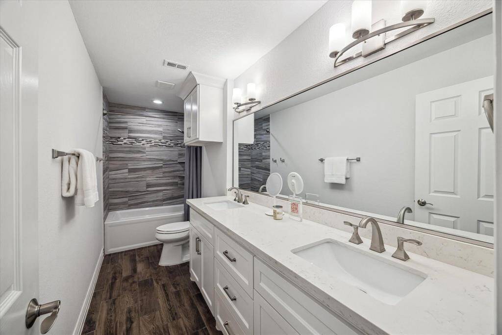 Everything is new in this secondary bathroom. The large vanity has ample storage and dual sinks.