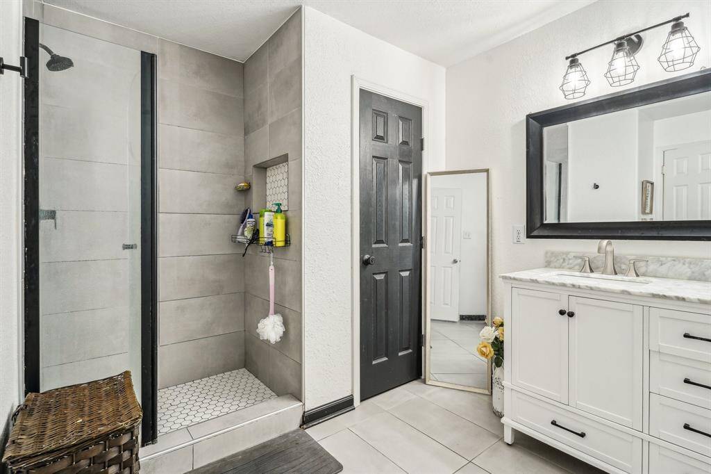 Ensuite primary bathroom featuring modern updates, glass shower door and fresh pain and floors!