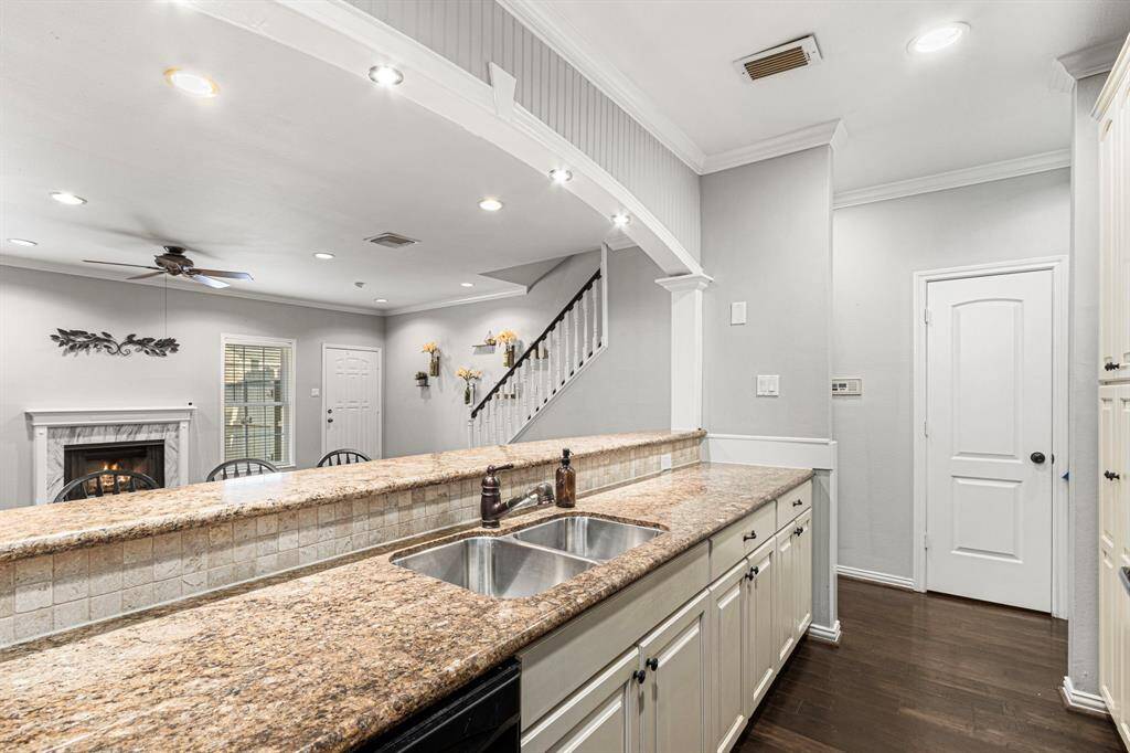 Elegant kitchen featuring an undermount sink, stylish stone backsplash, and refined crown molding throughout.