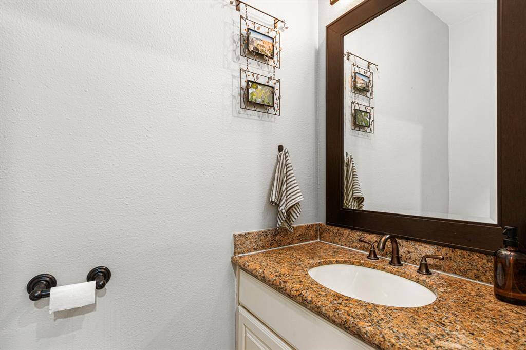 On the lower level, enjoy a stunning half bath featuring granite countertops and modern cabinets.