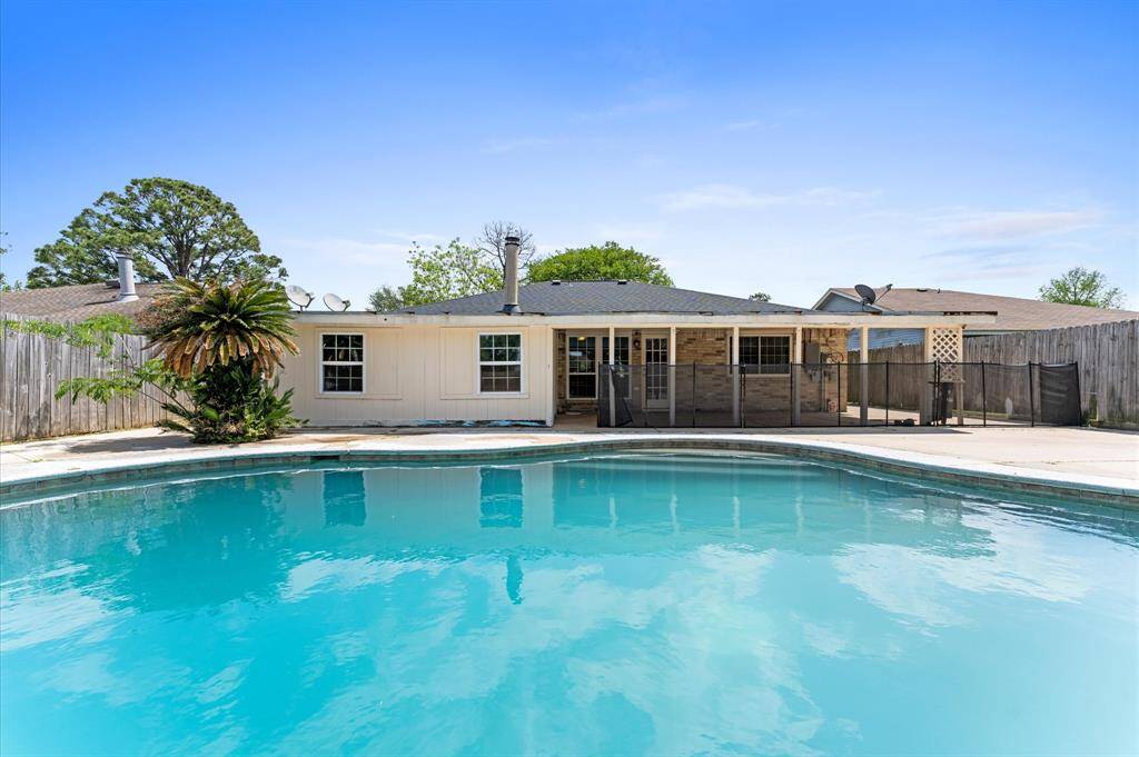 Serene backyard oasis featuring a sparkling pool and spacious patio, perfect for relaxation and entertaining.