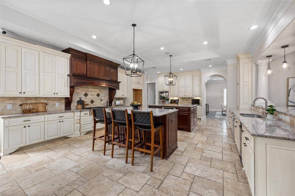 The heart of the home is this chefs dream of a kitchen! Featuring Double Jenn - Air Ovens, 6 Burner Gas Cooktop Jenn- Air range, equipped with a pot filler and handsome backsplash.
