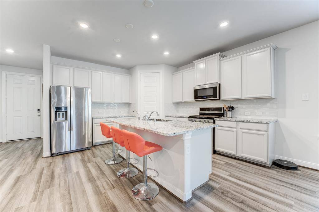 Kitchen offers plenty of cabinets, granite counter tops, gas stove and overhead microwave.