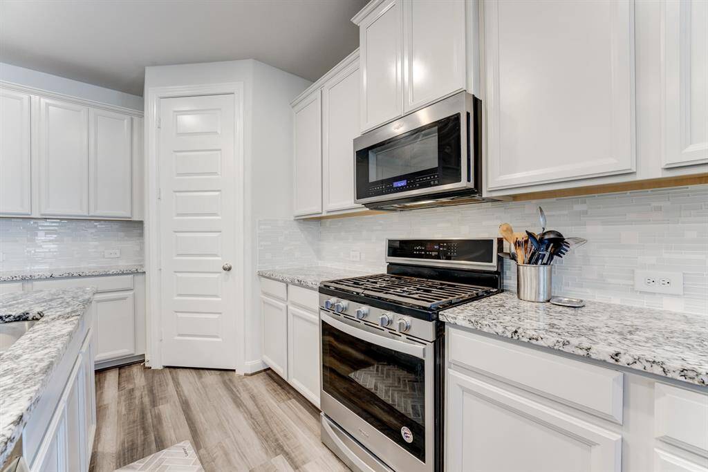 Gas stove, microwave and nice tile backsplash.