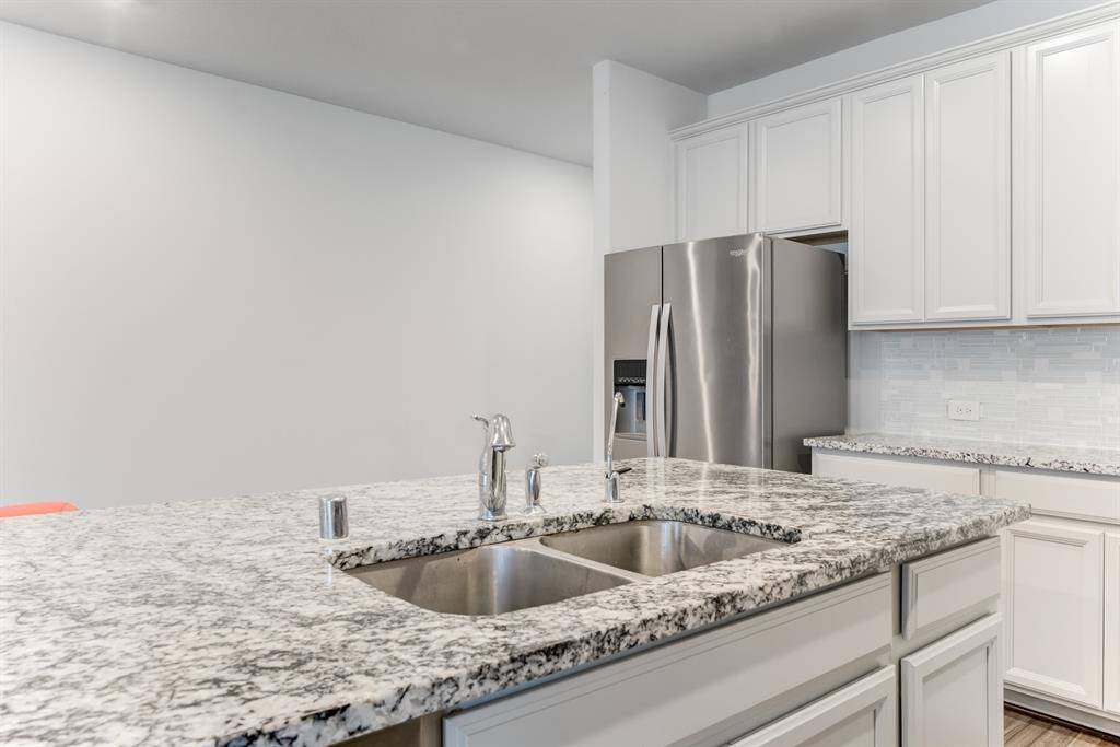 Deep stainless steel sink is located in the island.