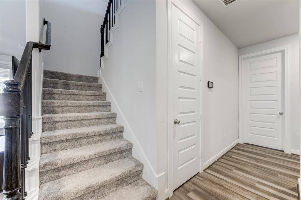 Stairs are in the middle of the home leading up to the game room,3 bedrooms and a secondary bath.  Door to the left is a large under the stairs closet area.  Door to the right leads to the utility room.