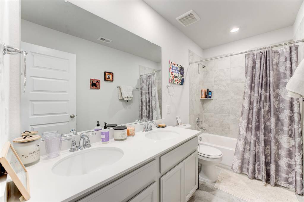 Secondary bathroom upstairs is a tub/shower combo with tile backsplash.  Secondary bathroom also offers double sinks.