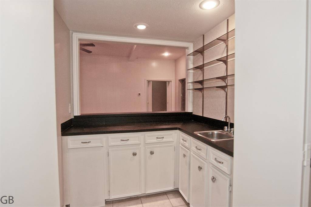 Kitchen, 10 foot ceilings here too, island, window at sink to side yard/driveway.