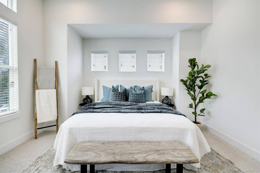 Serenity Awaits: A tranquil, spacious primary bedroom bathed in natural light, featuring elegant décor and plush comforts for a personal haven of relaxation.