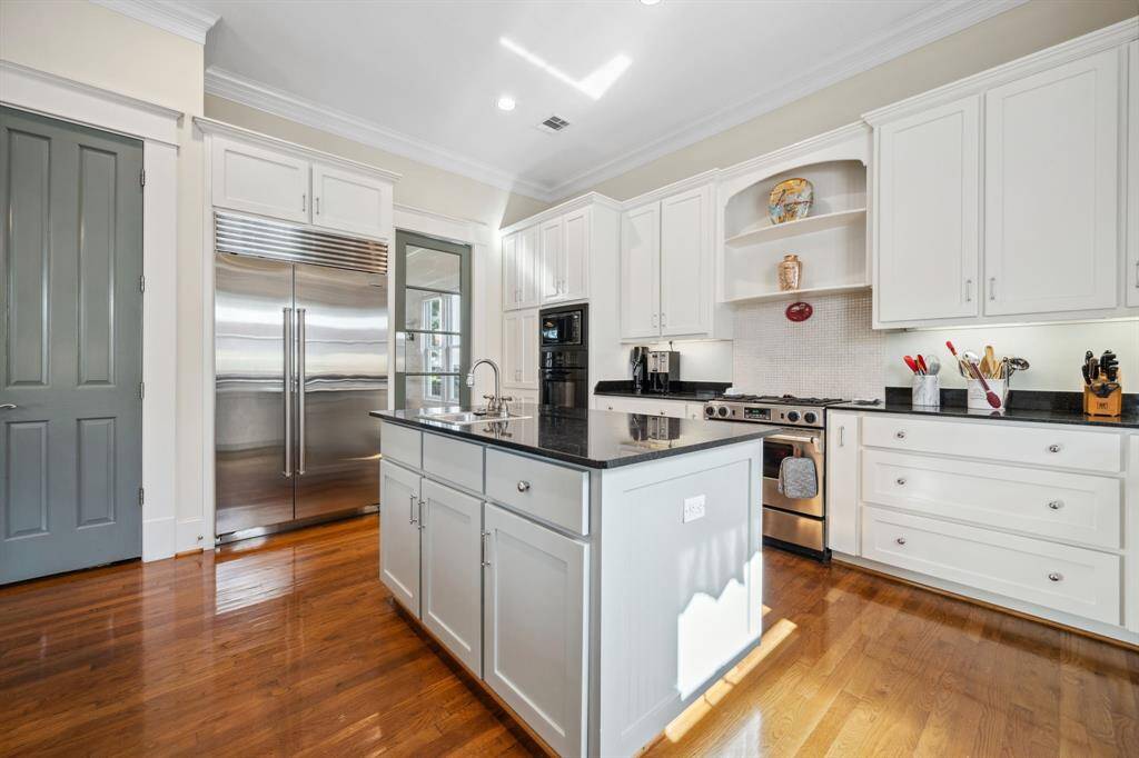 The kitchen is equipped with high-end stainless steel appliances, including a built-in Sub-Zero refrigerator, combining luxury and performance.
