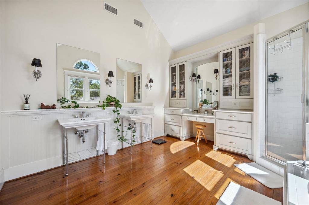 The primary bath features two pedestal sinks and a separate vanity, combining elegance and functionality for a luxurious experience.