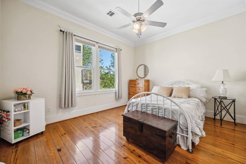 Secondary bedroom featuring high ceilings and beautiful hardwood floors, creating an open and airy atmosphere.