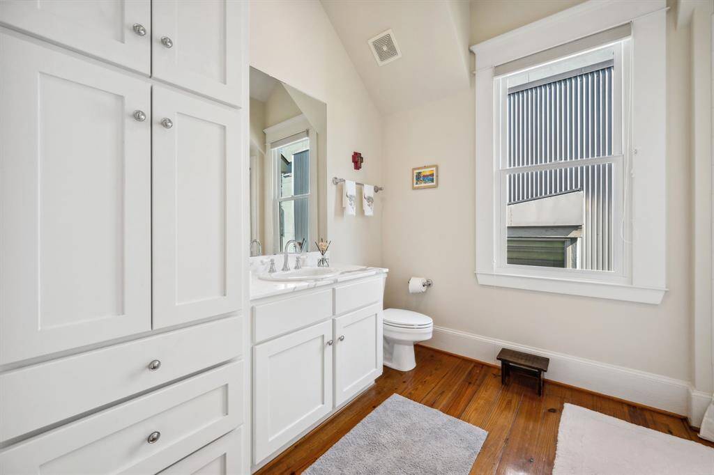 Secondary bathroom offering ample storage and a convenient shower-tub combo.