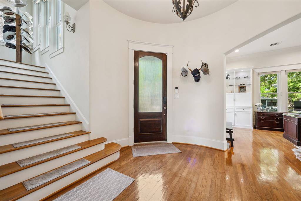 This welcoming entryway features polished hardwood floors and front door with frosted glass. Natural light brightens the space.