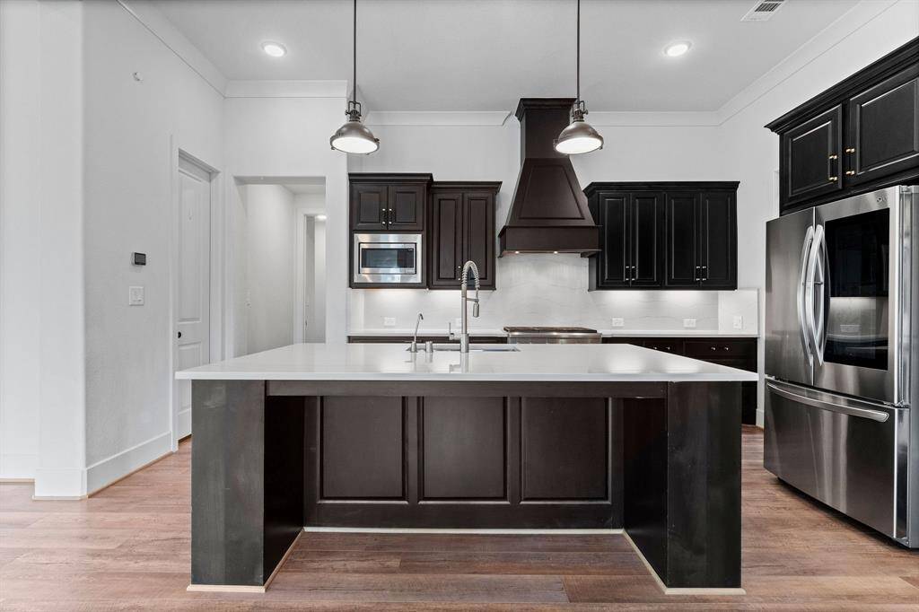 At the center of it all, a grand island serves as the true heart of the kitchen—offering abundant storage, casual breakfast seating, and striking pendant lighting. Whether prepping gourmet meals or hosting lavish gatherings, this space delivers both beauty and practicality in perfect harmony.