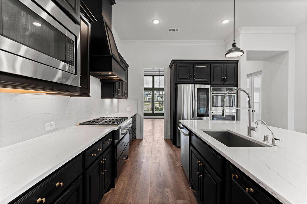 A pristine showcase of elegance and functionality, this extraordinary kitchen is designed to impress. Outfitted with top-of-the-line Cafe brand stainless steel appliances—including a professional-grade six-burner cooktop, double ovens, a third-rack dishwasher, and microwave—it seamlessly blends style with performance. Rich wood cabinetry offers abundant storage, while sleek quartz countertops provide ample workspace for culinary creations. LG refrigerator negotiable.