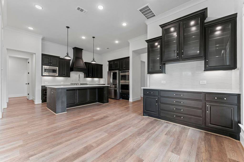 Additional breakfast area is great for family dinners or a morning cup of coffee!  Features include wood-look vinyl plank flooring, recessed lighting, crown molding, two windows with cordless solar shades, and a coffee bar area with Cambria quartz counters and under-cabinet lighting. Store your finest collectibles in the glass-front cabinets.