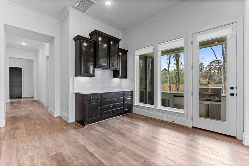 Panoramic backyard views from this roomy breakfast nook! This large space is adjacent to the kitchen and is lined in windows that give an awesome view of the backyard. The backyard and outdoor kitchen are easily accessed from this area to make outdoor entertaining a breeze!