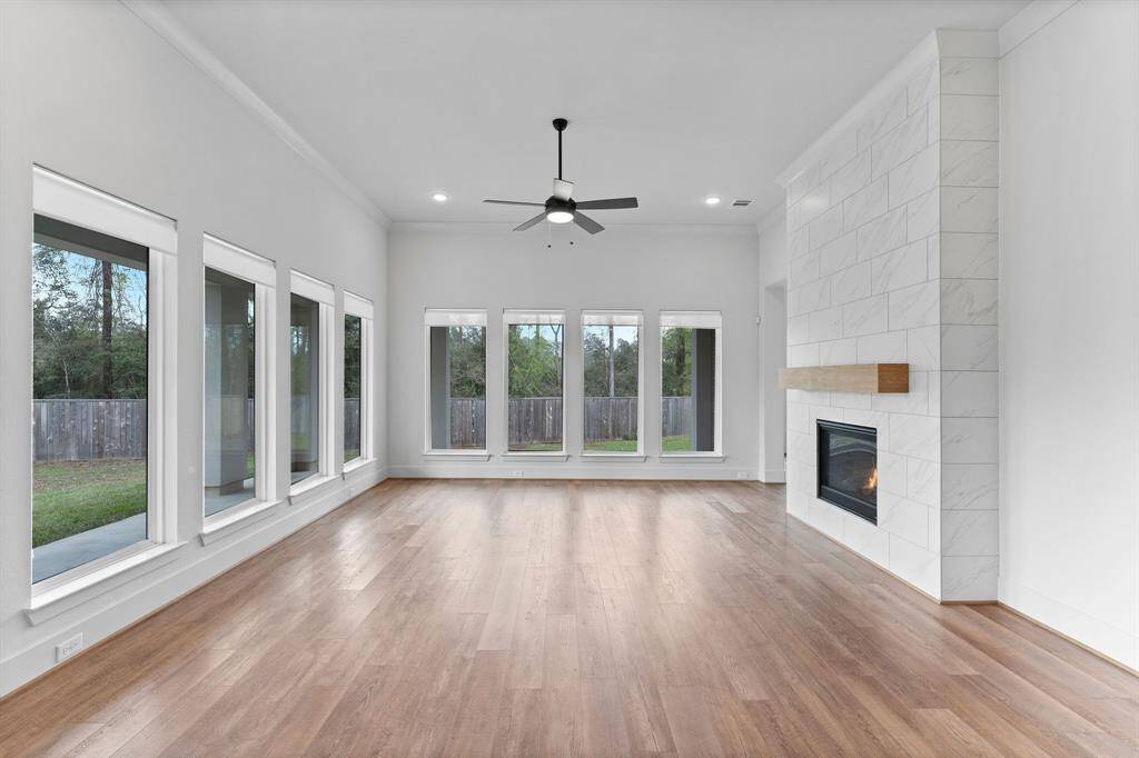 Bright, inviting, and thoughtfully designed, the Den offers the perfect space to unwind or gather with loved ones. Bathed in natural light from eight expansive windows across two walls, this elegant space showcases views of the lush backyard and the covered porch with outdoor kitchen.