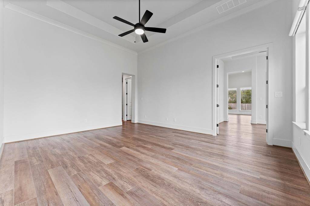 The sophisticated suite features wood-look vinyl plank flooring, a tray ceiling with crown molding, a lighted ceiling fan, and a generous walk-in closet for all your storage needs. Enjoy multiple points of access—through double doors leading from the sunroom or from a convenient hallway off the Kitchen. Plus, with direct access to the laundry room, it’s as functional as it is luxurious.
