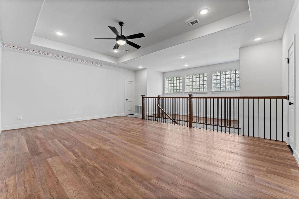 The room features beautiful wood-look vinyl plank flooring, three sunny windows that brighten the space, recessed lighting, a tray ceiling, and a lighted ceiling fan—creating the perfect environment for hours of family memories. Adjacent to the game room, you'll find a small loft area that adds even more charm to the space. The room also offers convenient access to two walk-in attic doors for extra storage. Be sure to take the virtual tour to fully appreciate this expansive area!