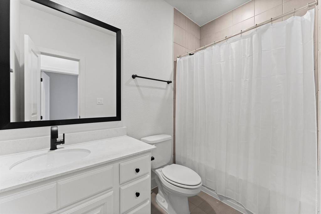 3rd full bathroom for Bedroom 4 and Game room guests includes single sink with quartz counter top, tile flooring, toilet, framed mirror, hallway linen closet, and tiled shower/tub combo.