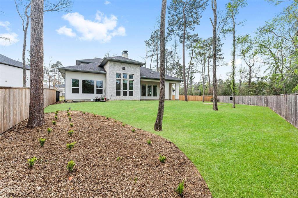 The yard is filled with abundant sunshine, creating a bright and cheerful atmosphere, yet it's also dotted with mature trees that provide lovely shade and a touch of natural beauty. The home is equipped with front and back gutters, complete with gutter guards, making rainwater management a breeze and keeping the exterior well-maintained.