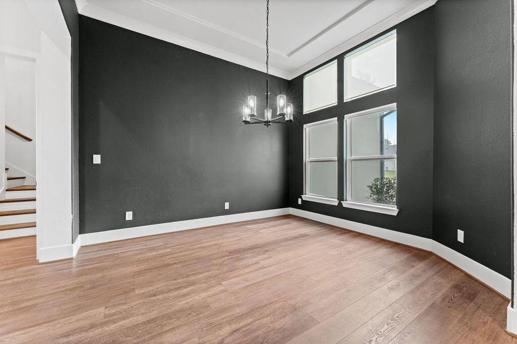 Host unforgettable gatherings in this exquisite formal dining room, where elegance meets functionality. Rich wood-look vinyl plank flooring sets a warm, inviting tone, while large double windows with cordless solar shades bathe the space in natural light.
