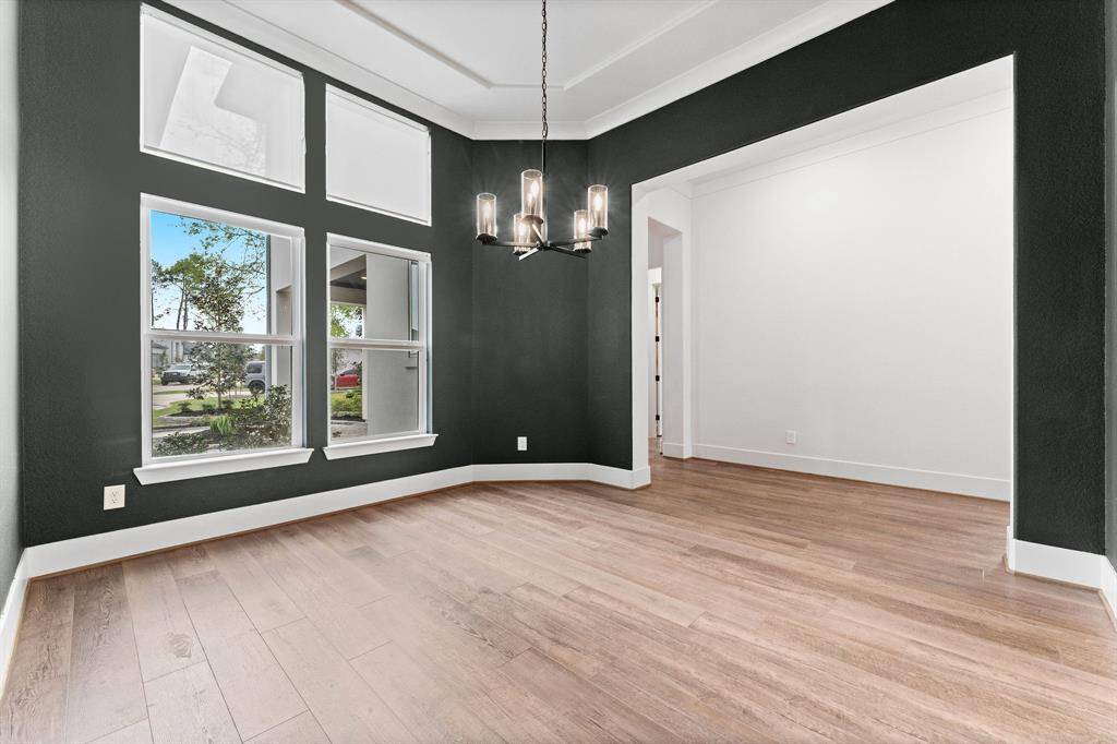 Designed to accommodate any dining arrangement, this room effortlessly showcases sophistication with its dramatic painted walls, refined tray ceiling, and intricate crown molding. A stunning designer chandelier serves as the perfect finishing touch, elevating every occasion.