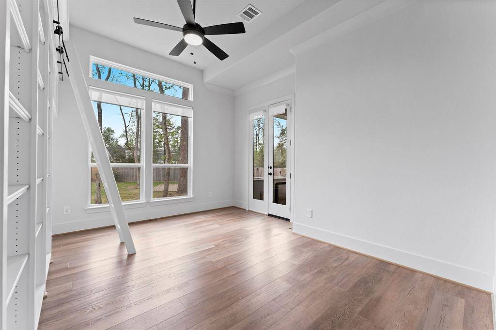 Flooded with natural light from two oversized windows with overhead transoms and cordless solar shades, the space feels airy and bright. For added convenience, enjoy direct access to the covered porch and outdoor kitchen—perfect for a midday retreat or alfresco meetings.